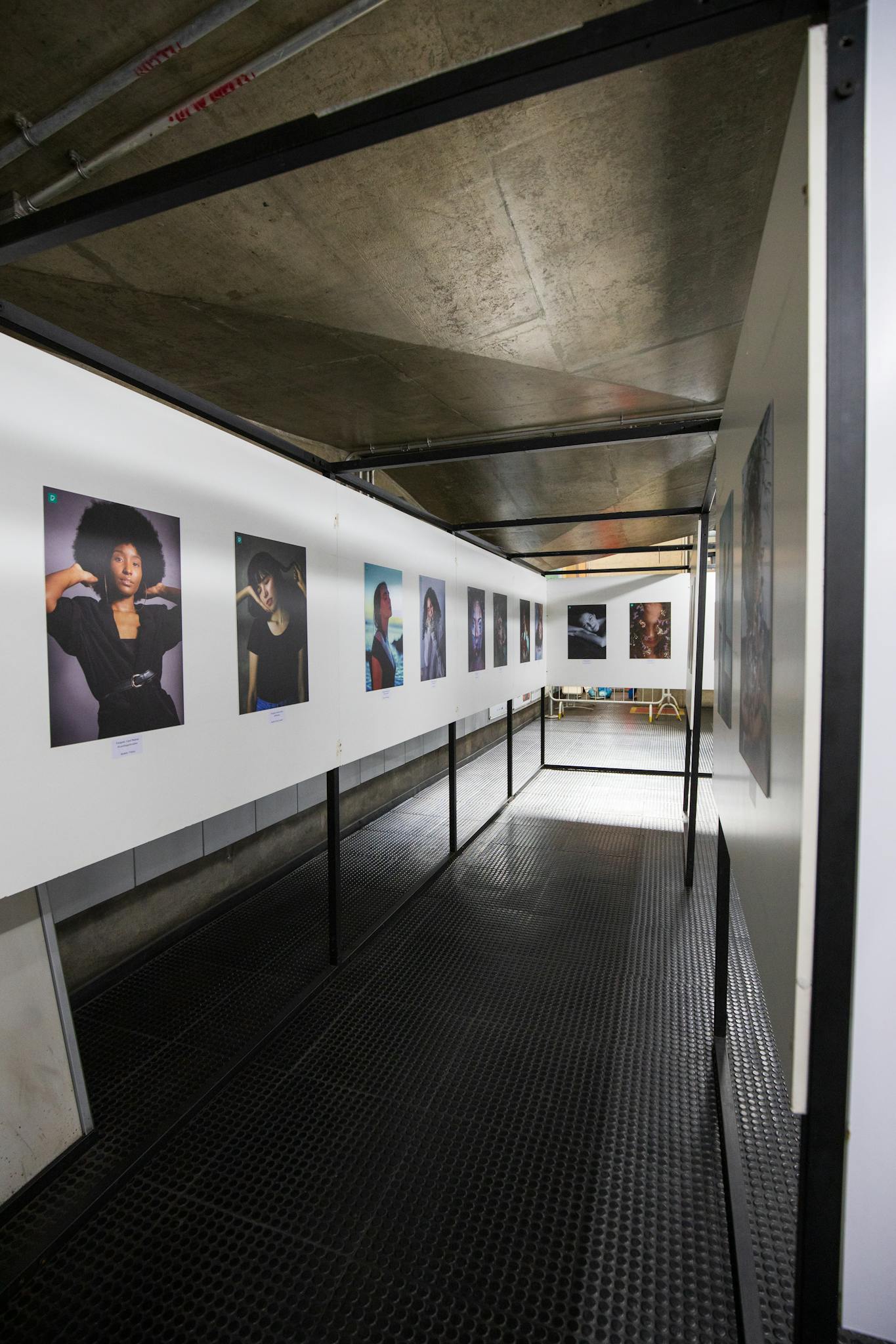 Explore modern art in a gallery setting with displayed photographs along a corridor.